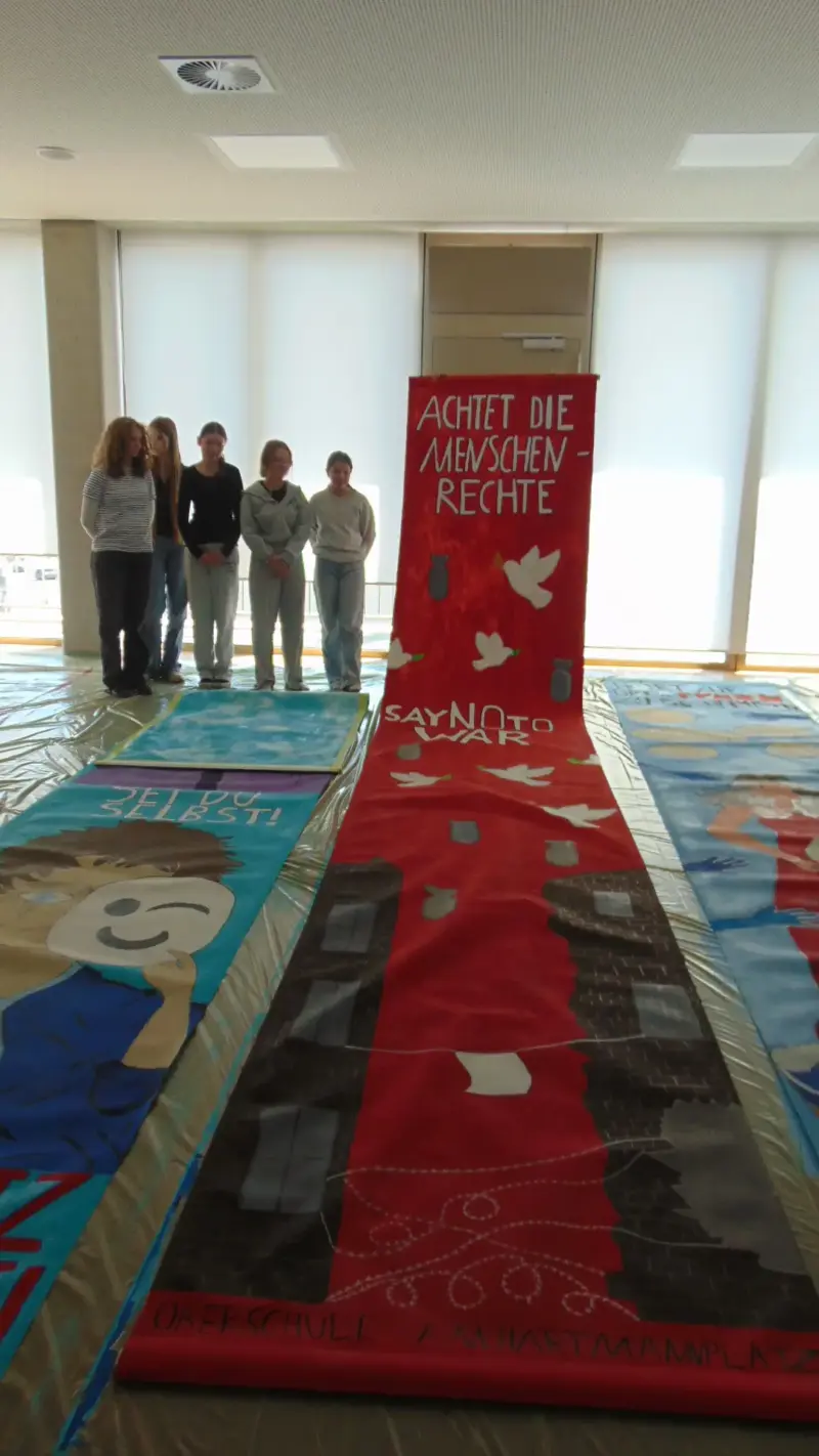 Fünf Schülerinnen am Banner Achtet die Menschenrechte